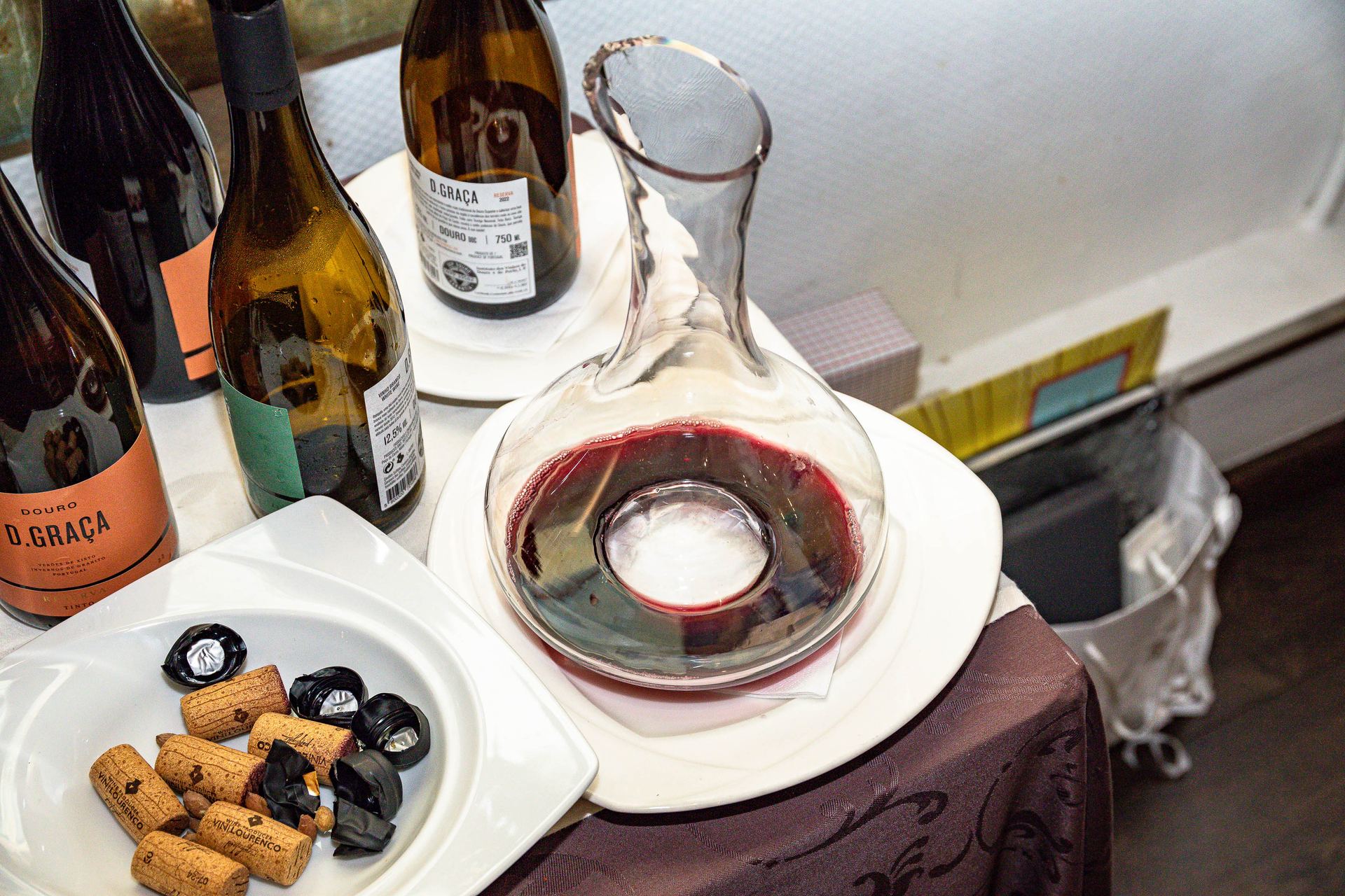 Carafe de vin rouge et bouteilles sur une table dressée