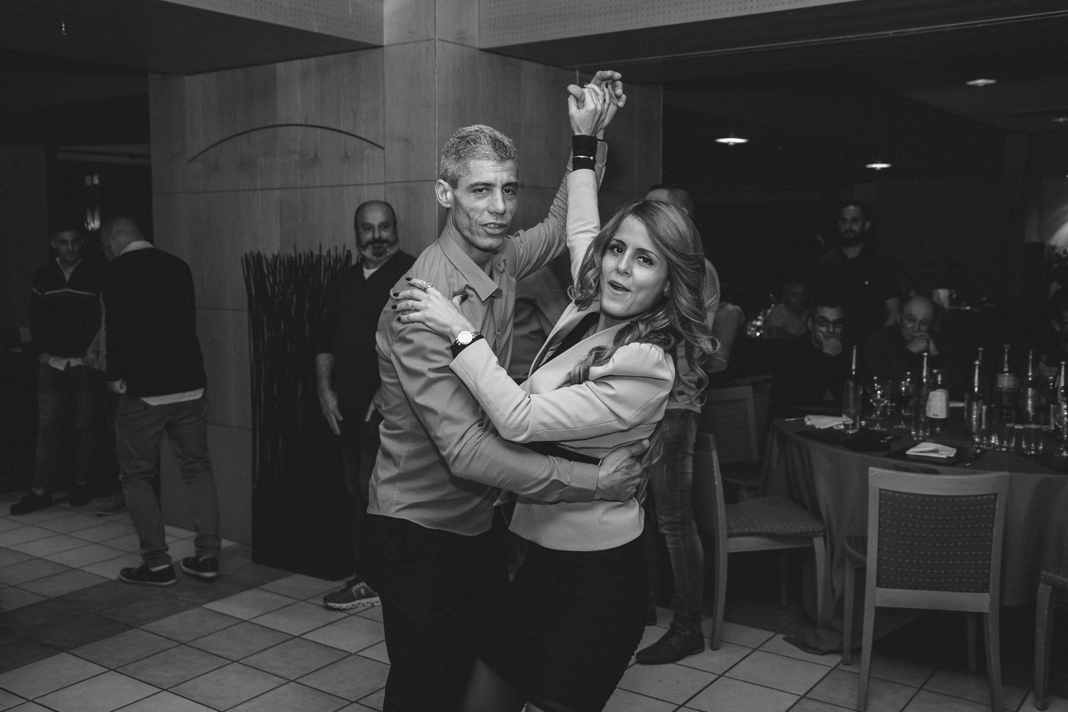 Un couple dansant de face, bras levé, soirée d’entreprise en noir et blanc