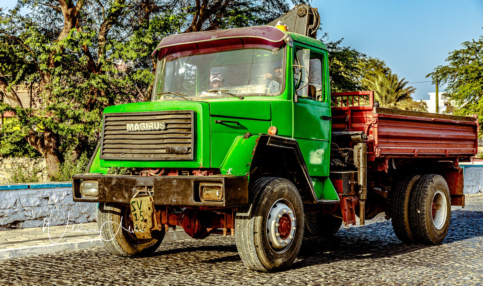 Ancien camion vert Magirus, grue de chargement, rue pavée